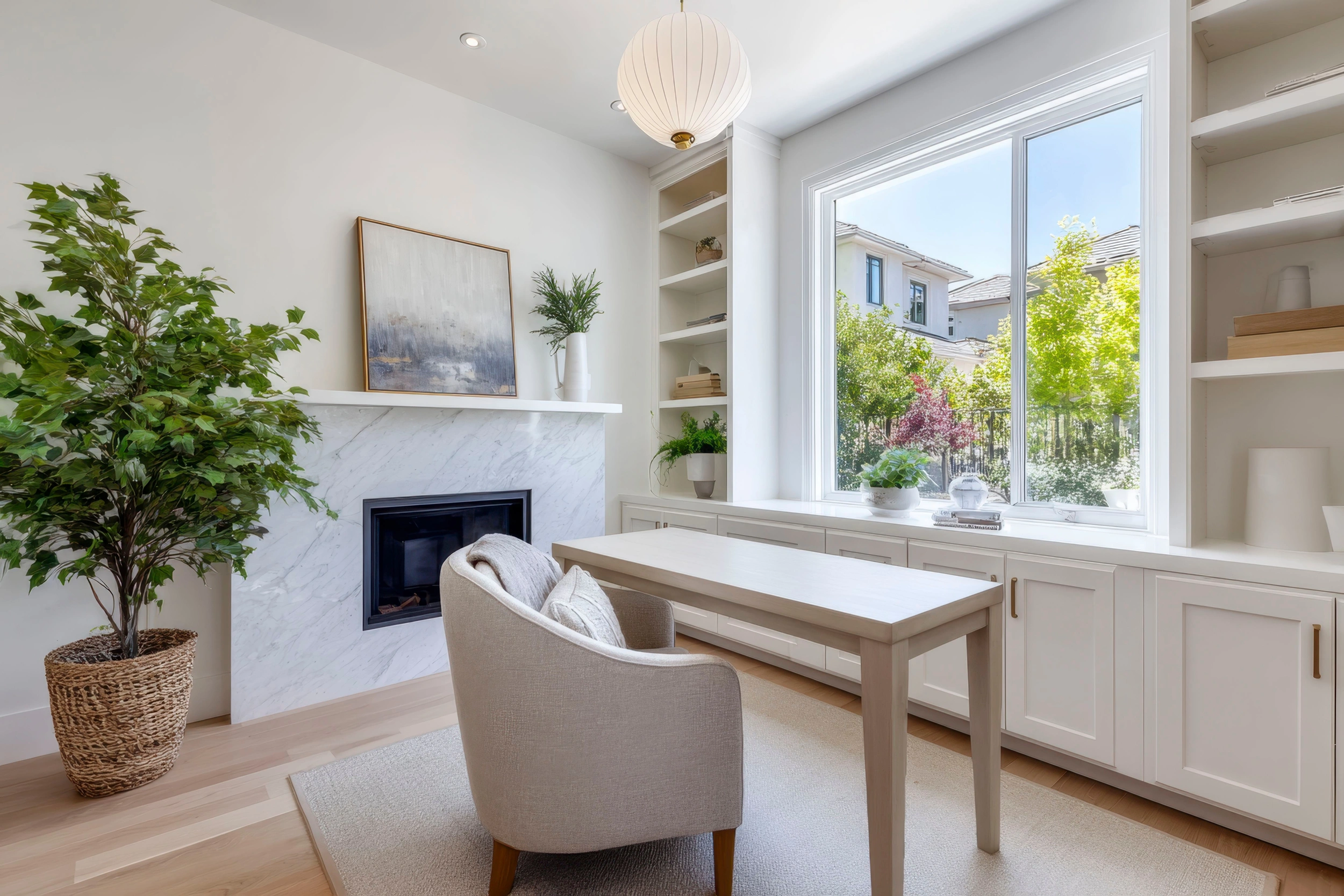 White built-in living room joinery flanking a fireplace, with a window desk and console