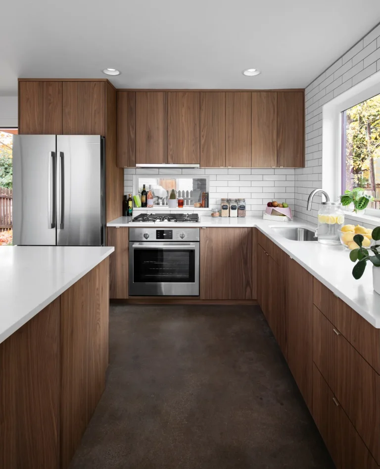 L-shaped timber kitchen with a white stone benchtop and integrated oven and fridge